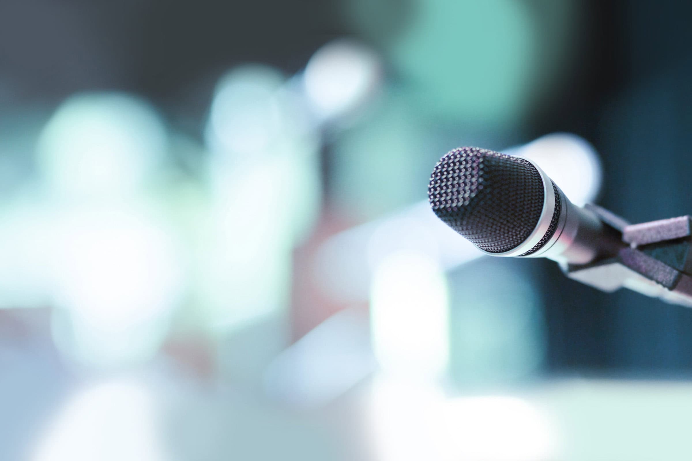 A microphone on stage with a blurred background, capturing the essence of a live performance.