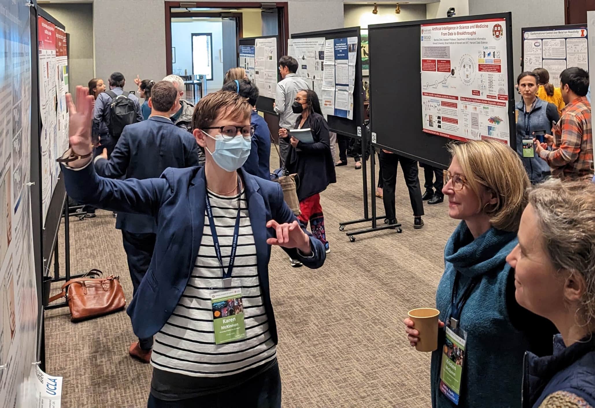 People wearing face masks and standing around a poster promoting safety measures.