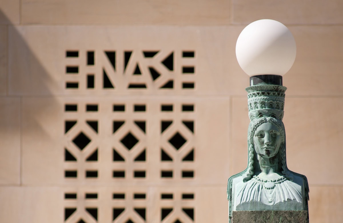 A statue of a woman holding a lamp on top