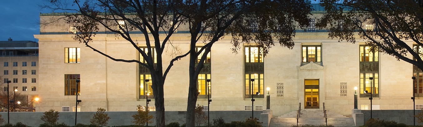 A beautifully illuminated building at night, surrounded by trees, creating a captivating nighttime scene.